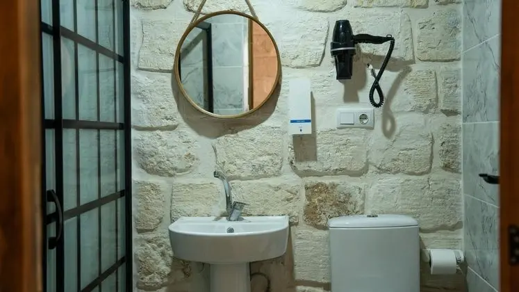 Deq Odası: Şık Bir Ayna, Saç Kurutma Makinesi Ve Modern Donanımlarla Tamamlanan Otantik Taş Banyo Alanı.