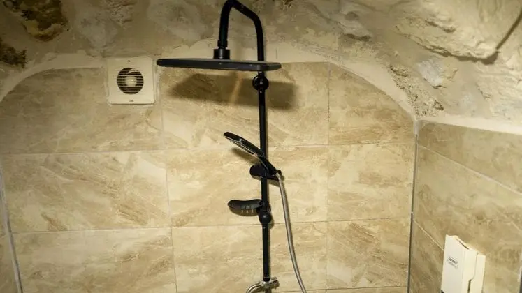 Harmel Odası: Modern Detaylarla Donatılmış, Şık Ve Konforlu Siyah Duş Başlığı Ve Banyo Alanı.